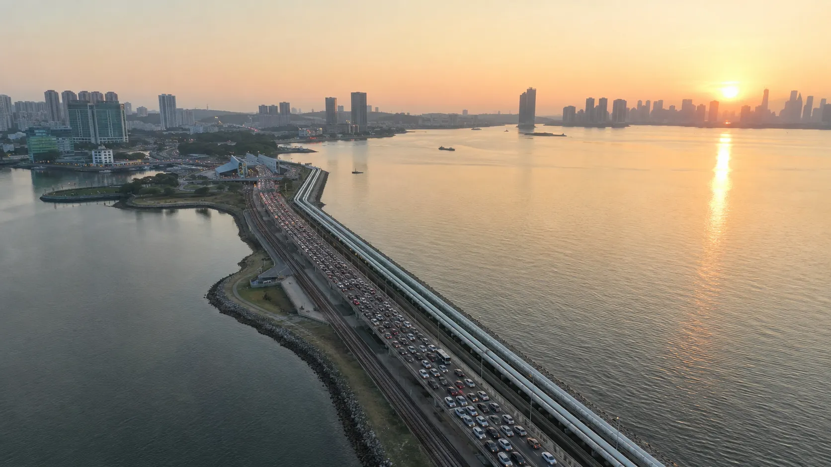 Aerial view of the Johor-Singapore Causeway at dawn with commuter traffic crossing between the two countries