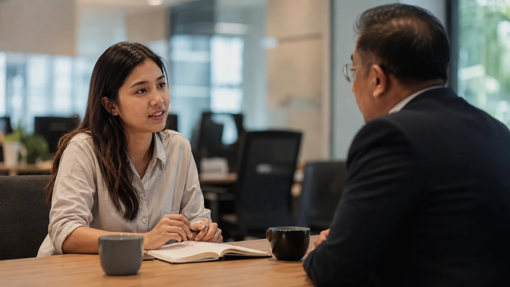 A young Malaysian employee in a one-on-one review meeting with a manager