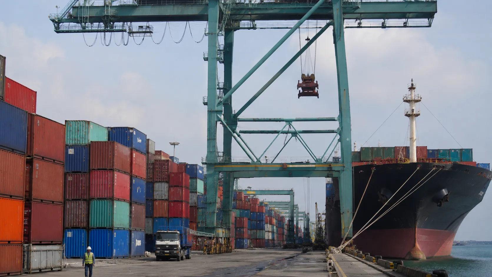 Stacked shipping containers and a gantry crane at Port Klang, Malaysia's main export gateway