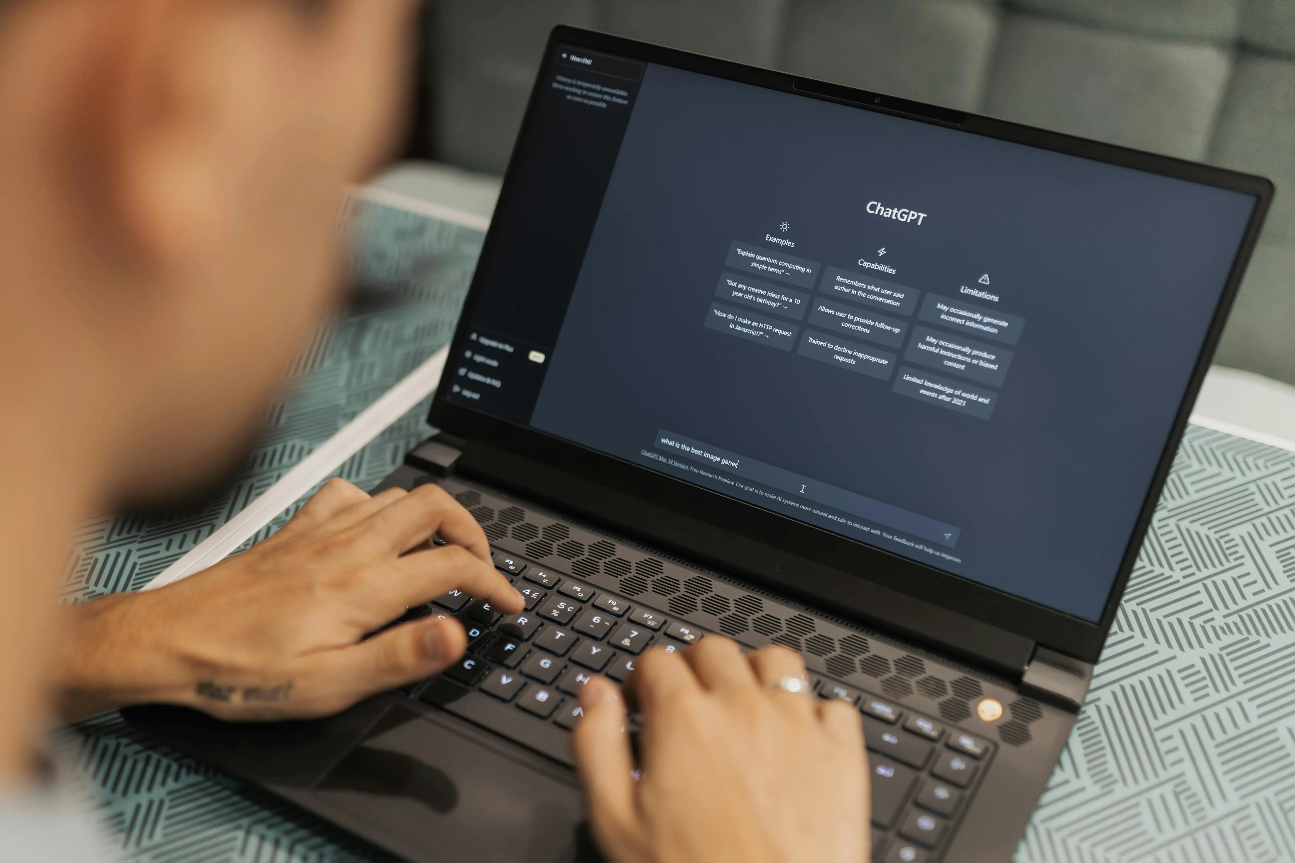 A man enters prompt into ChatGPT on the laptop