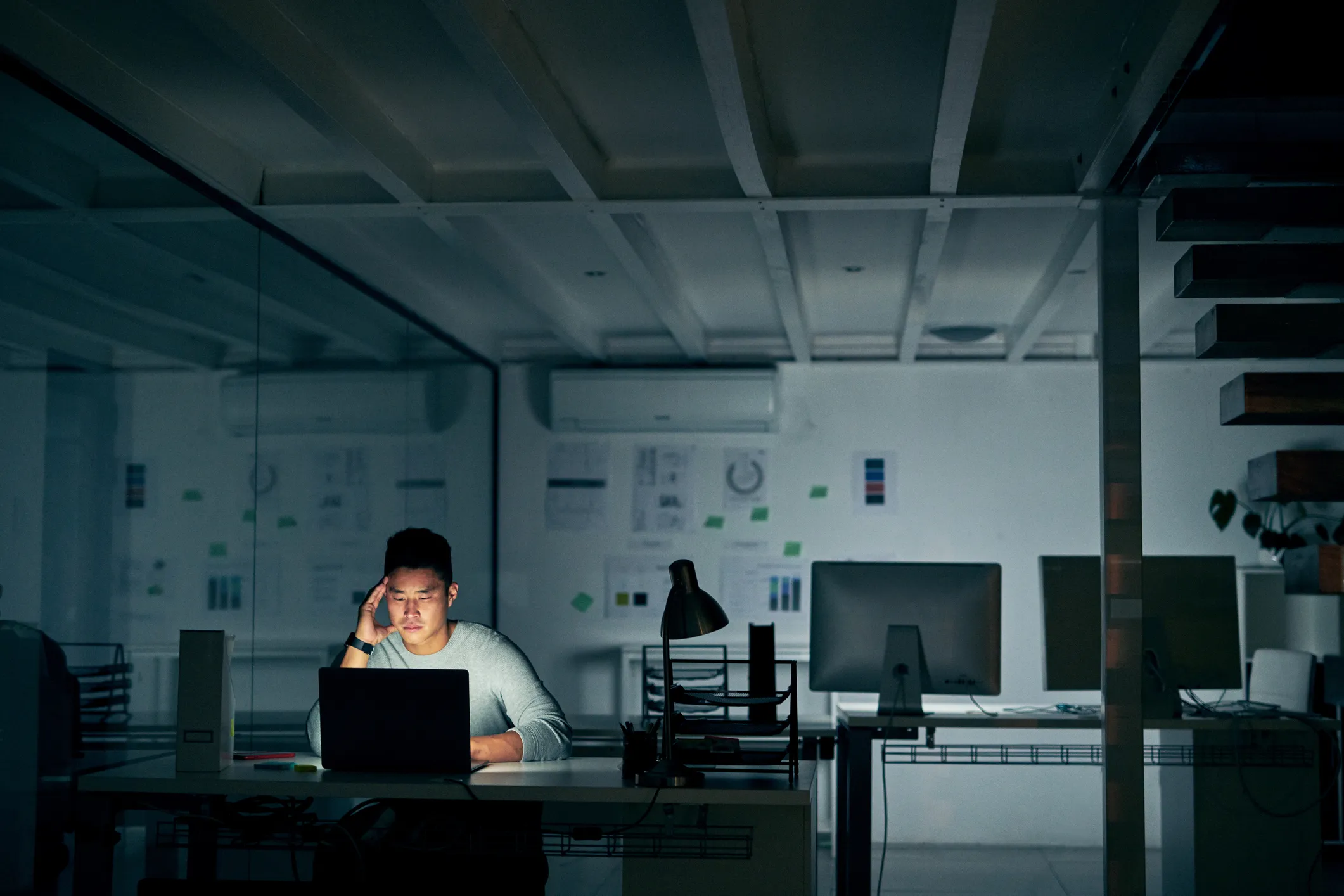 A guy working alone in the office in the dark