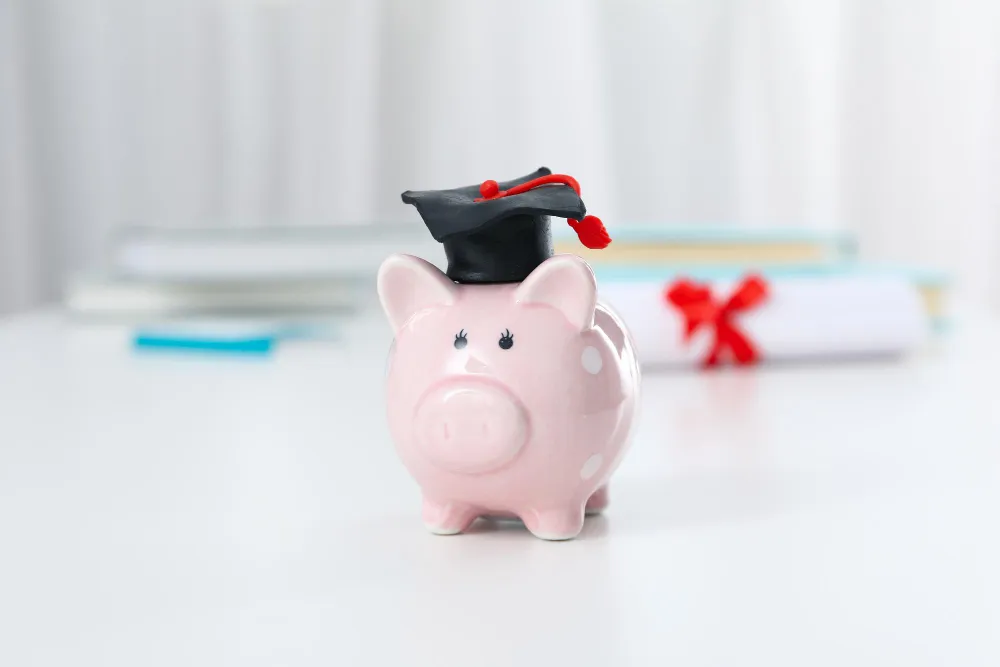 piggy bank with a graduate's cap on a white table